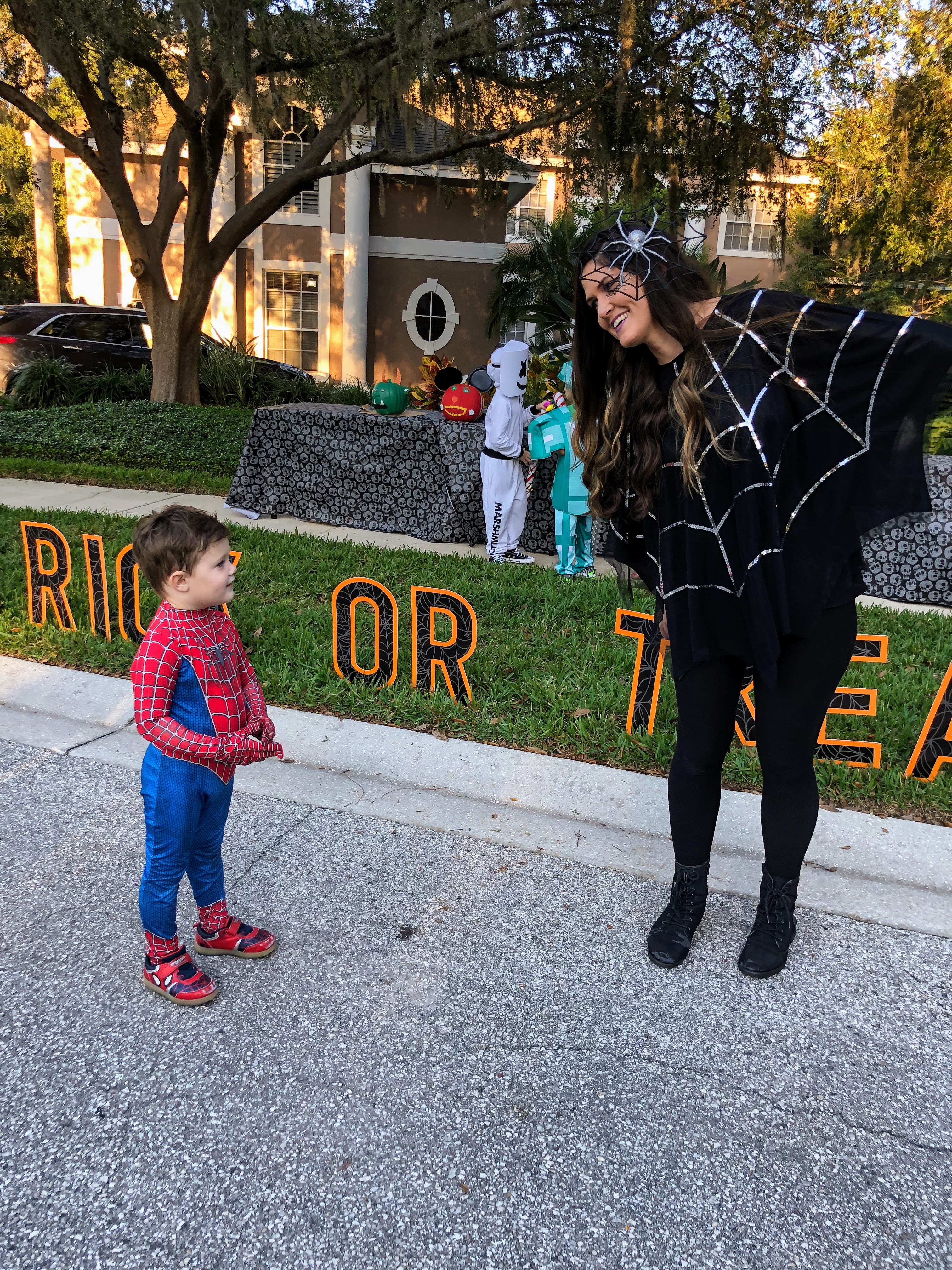 mom dressed up as spider web with boy in spider-man costume
