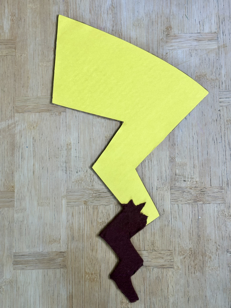 Handmade Pikachu tail for a Pokémon Family Costumes theme, created from cardboard, yellow construction paper, and brown felt, designed for a child’s Pikachu costume.